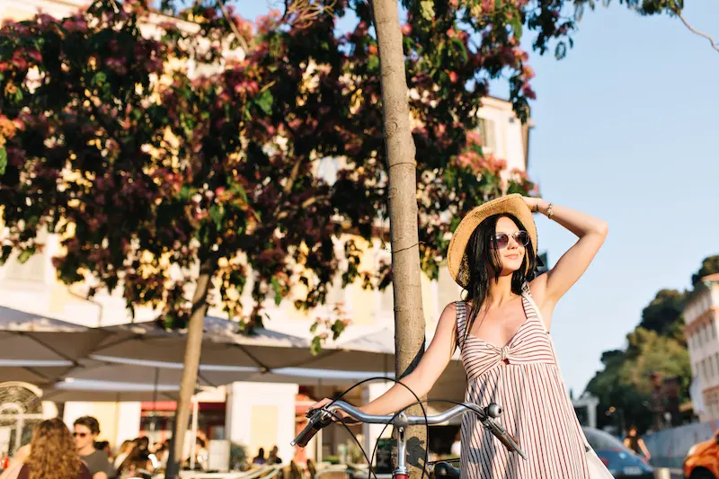 A female traveler with a premium Solebike electric bicycle in a picturesque narrow street of the Plaka district, Athens.