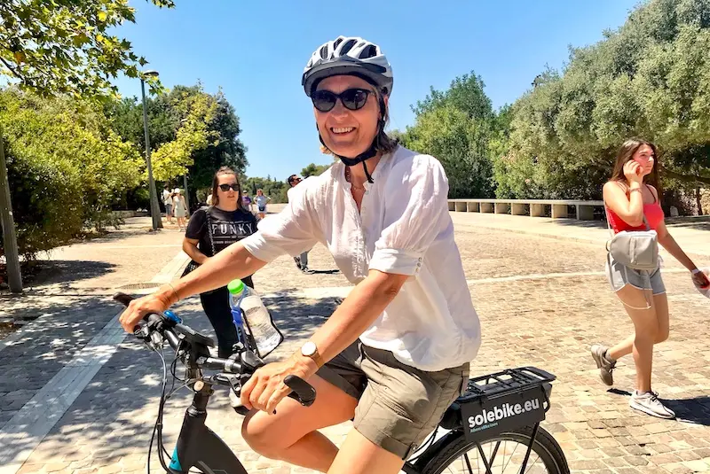 Female rider on a premium electric bike at the Dionysiou Areopagitou pedestrian promenade near the Acropolis in Athens.