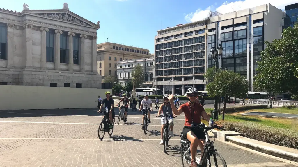 Small group of riders passing the Academy of Athens on a private eBike tour