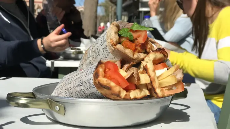 Greek souvlaki pita with fries and tomato served at an Athens street food stop