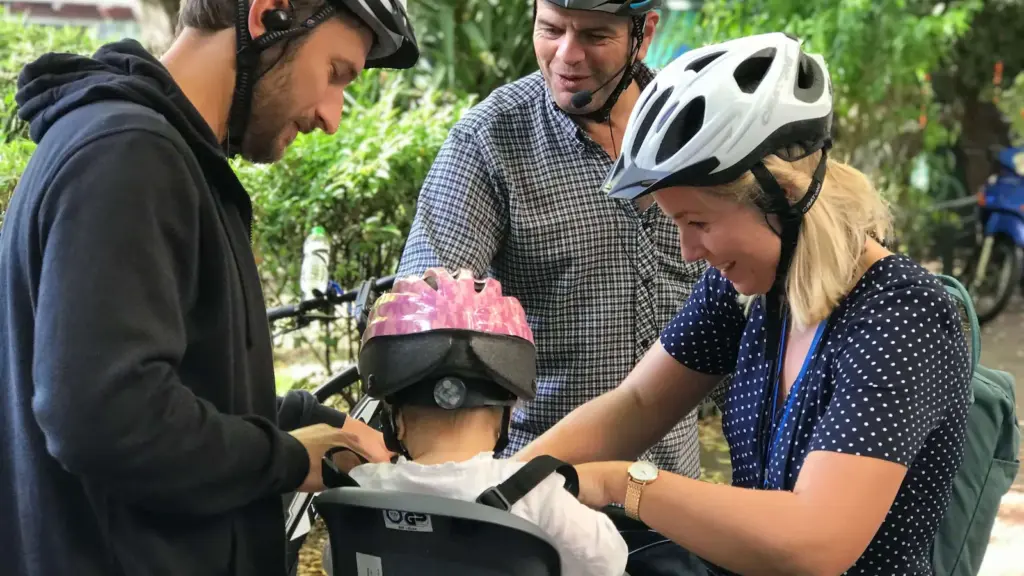 Parents and guide securing a baby in a bike seat before a family eBike tour in Athens
