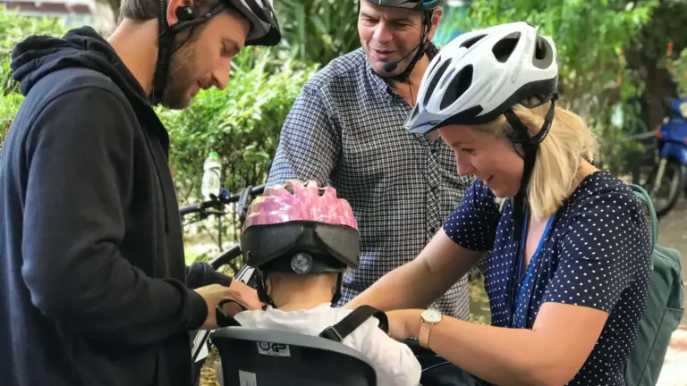 Parents and guide securing a baby in a bike seat before a family eBike tour in Athens
