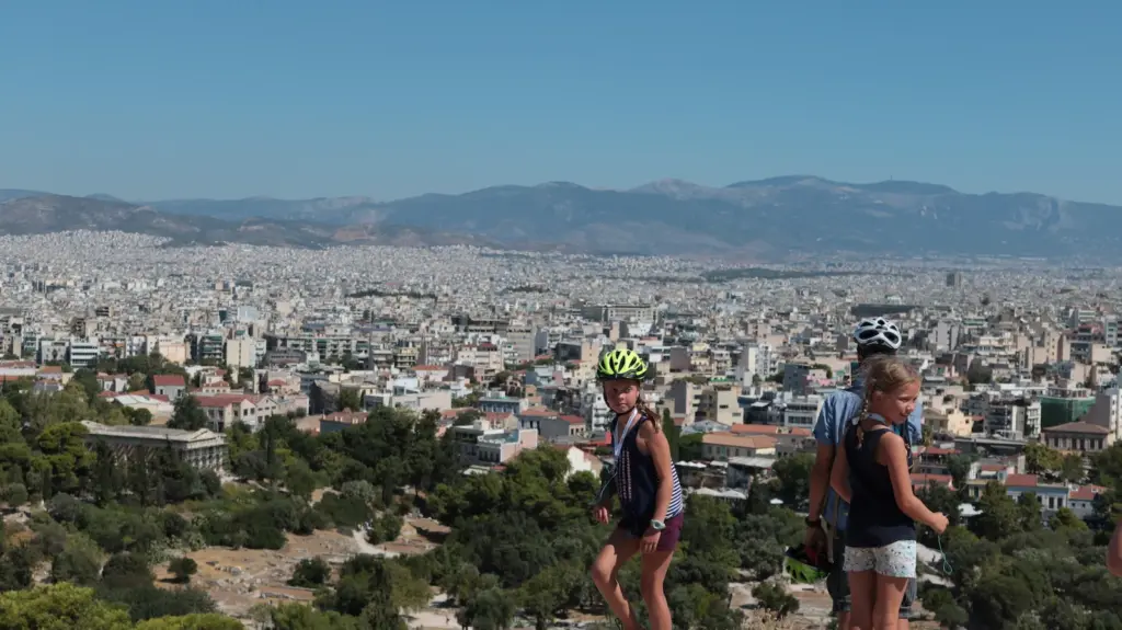 Children wearing helmets at an Areopagus Hill stop during a family eBike tour in Athens