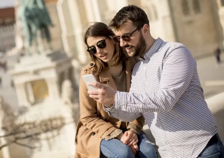 Young couple using a smartphone audio guide during a self-guided Athens tour
