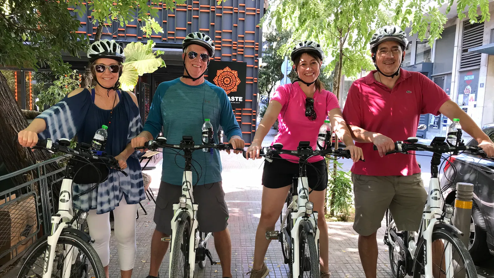 Two couples smiling on eBikes at the start of an Athens eBike tour