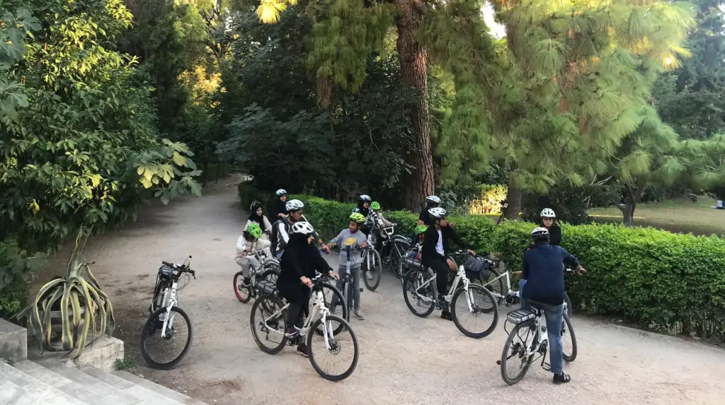 Family bike tour group stopping in the National Garden in Athens