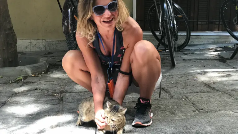 Female rider playing with a cat during a Plaka stop on an Athens eBike tour