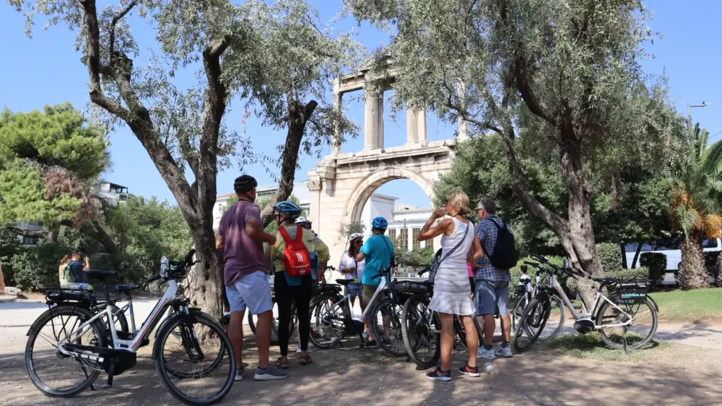 Group of guests with eBikes during a guided stop at Hadrian’s Gate in Athens