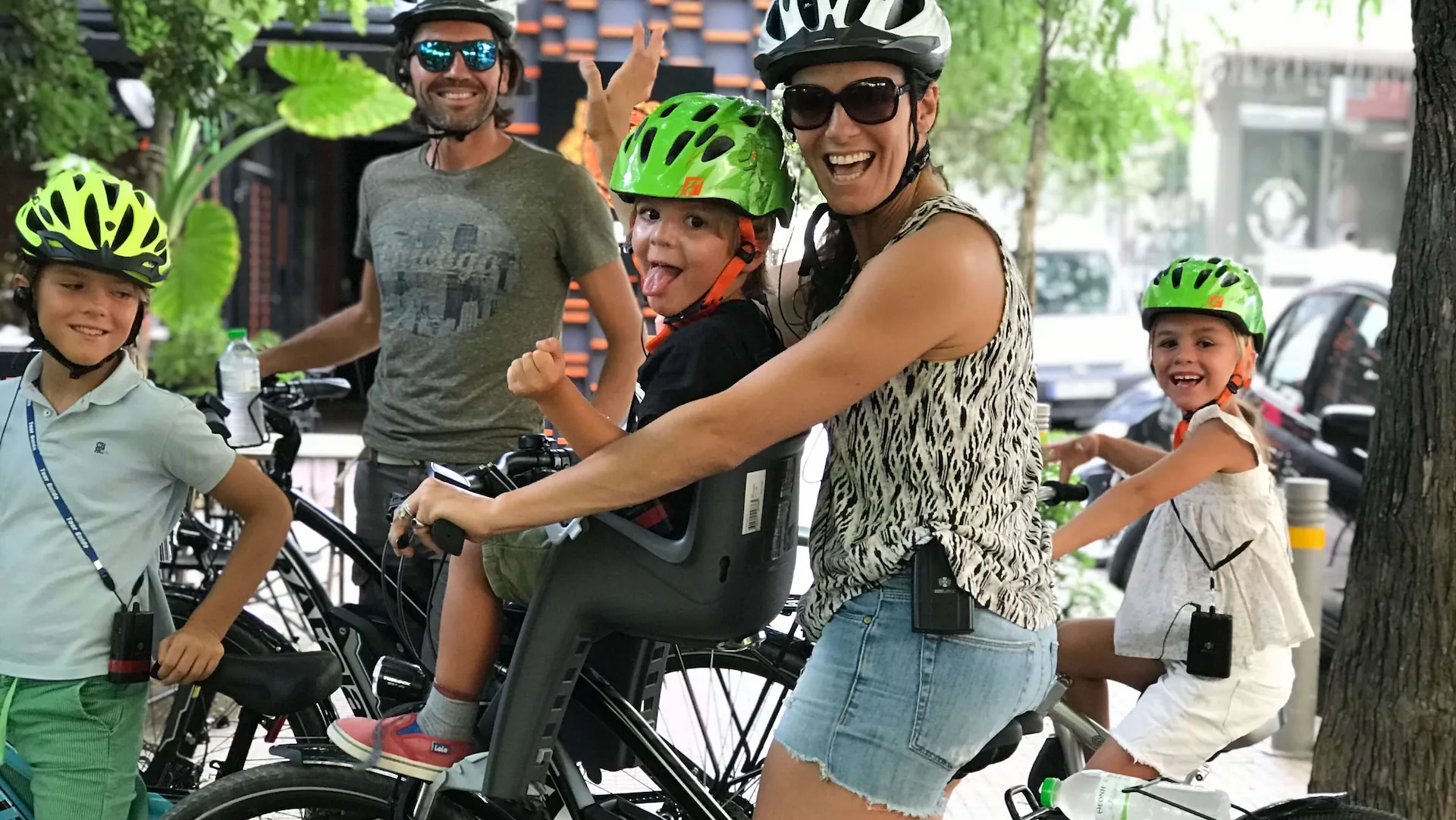 Parents and three children smiling on eBikes before a family tour in Athens