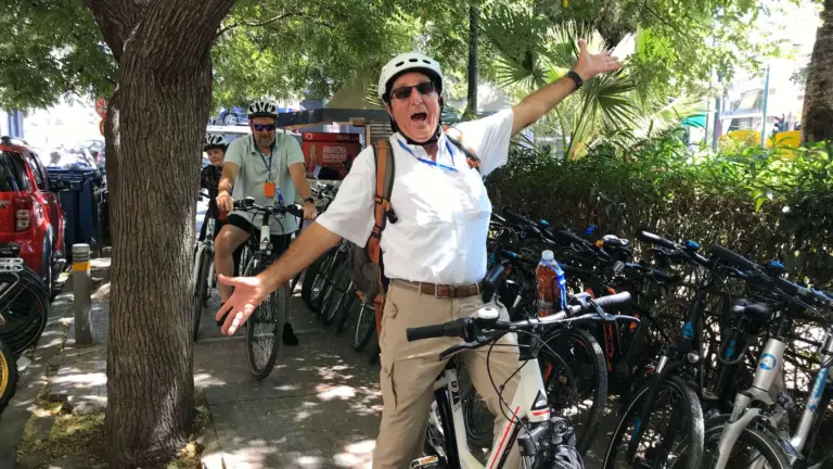 Senior man smiling with open arms on an eBike tour in Athens