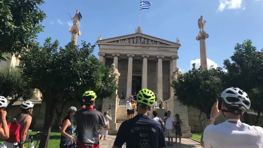 Bike tour group viewing the Academy of Athens, one of the city’s iconic neoclassical buildings