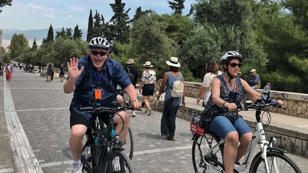 Senior couple riding eBikes along Thissio promenade during an Athens shore excursion