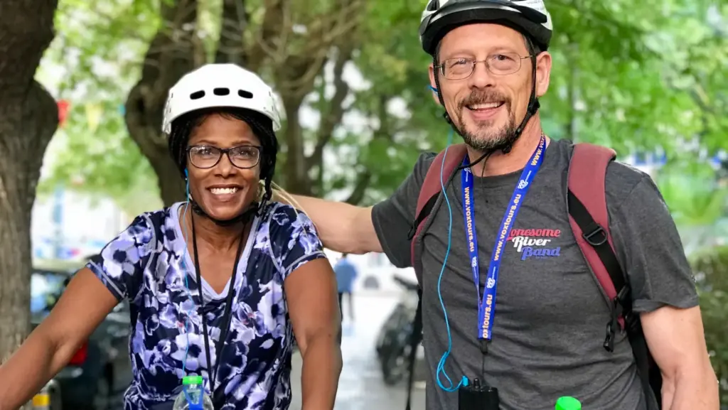 Two smiling riders wearing helmets before starting an Athens eBike tour from the Solebike office