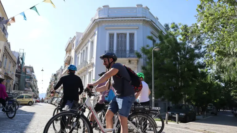 Riders passing a neoclassical house in Thissio during an Athens eBike tour
