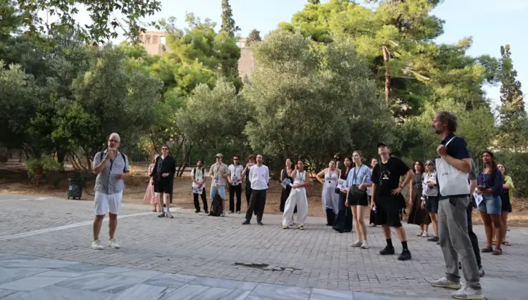 Participants on an Athens architecture walk studying neoclassical houses near the Acropolis