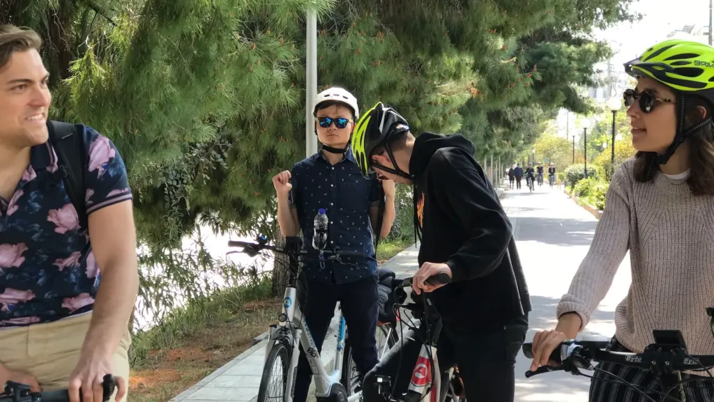 Athens Riviera Coffee Ride group gathered with eBikes on a shaded city bike lane