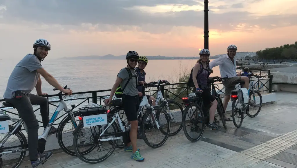 Group of eBike riders pausing at Faliro promenade during the Athens Riviera Coffee Ride at sunset