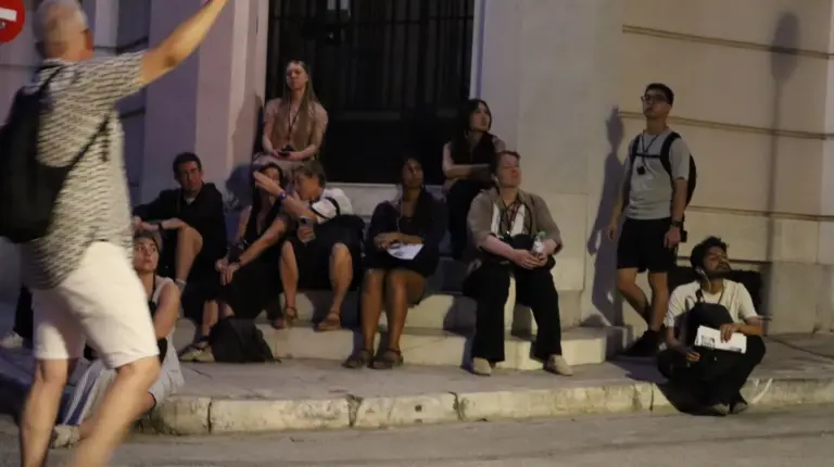 Academic group listening to Nasos explain interwar apartment architecture in Athens